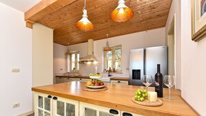 A kitchen with wooden cabinets, a wooden countertop, and hanging pendant lights. - House 2303/98197 (Istria - Rakovci), 10000m from the beach (Rakovci)