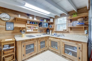 Une cuisine avec des meubles en bois, un four à micro-ondes et divers ustensiles de cuisine.