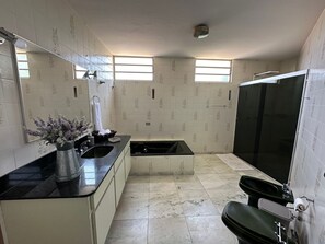 Eenvoudige villa | Badkamer | Een douche, een regendouche, een haardroger, een bidet