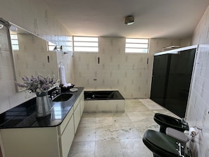 Eenvoudige villa | Badkamer | Een douche, een regendouche, een haardroger, een bidet