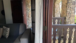 An open door leading to a balcony with stone walls and a wooden railing. - Recanto Amana Casa Centro de SJBVista (Sao Joao da Boa Vista)