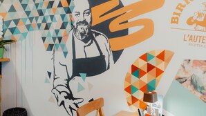Un mur orné d’un motif géométrique et portant le logo de « Birra L’Auta ».