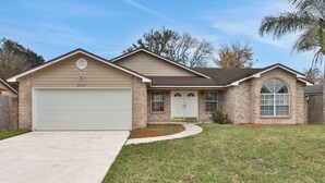 A two-story house with a garage, a front entrance, and a small front yard. - Homey 3/2, near Fleming Island (Middleburg)