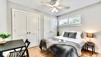 2 habitaciones, escritorio y tabla de planchar con plancha