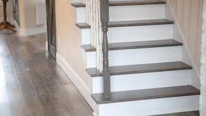 A staircase with wooden steps and a dark handrail. - Hôtel à la maison - L'Ancrage (Magog)