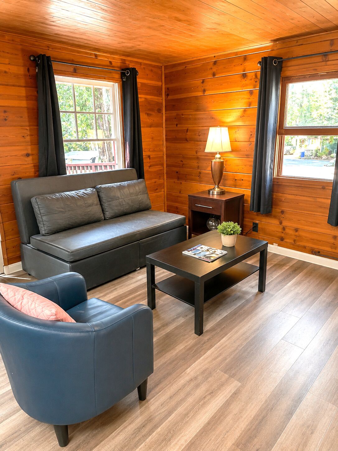 A cozy room with a sofa, a chair, a table, and a lamp.