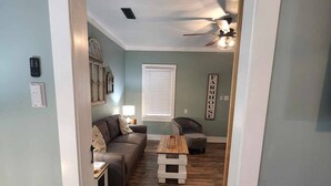 A living room with a sofa, coffee table, and a ceiling fan. - Pickwick Getaway in the Groves 7th NT Free!
(Counce)
