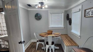 A compact kitchen with a dining table, white chairs, and a wooden bench. - Pickwick Getaway in the Groves 7th NT Free!
(Counce)