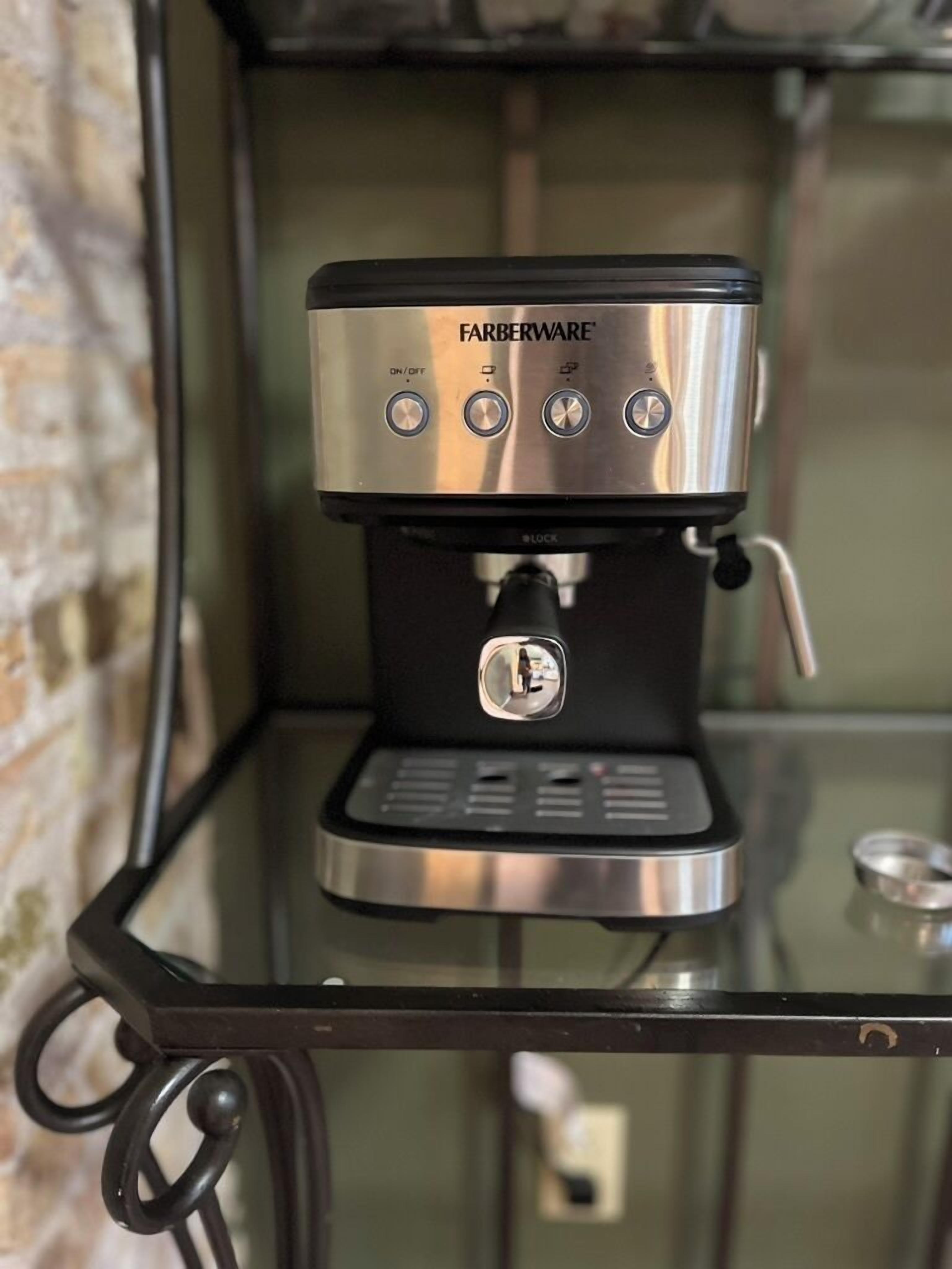 A Farberware espresso machine on a glass table with a metal frame.