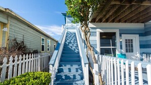 A staircase leading to a blue house with white railings and a white picket fence. - Upper Unit Beach Rental in Galveston Near Strand, Pleasure Pier & Restaurants! (Galveston)