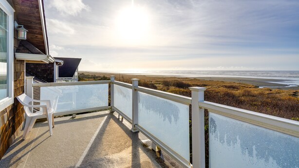 Ein Balkon mit Blick auf den Strand und das Meer.