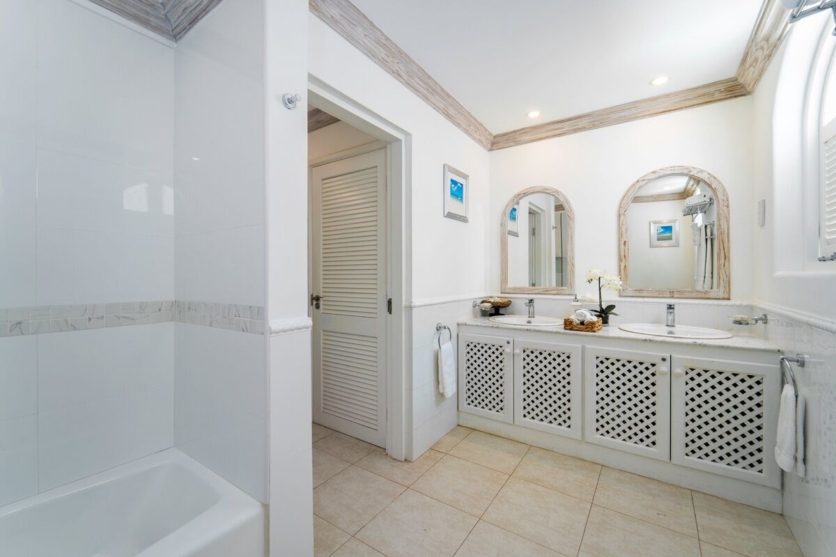Un baño con bañera, dos lavamanos y ducha.