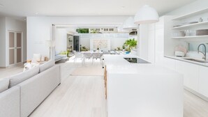 Een moderne keuken met witte kasten, een centraal eiland en hanglampen.