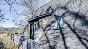A rustic cabin with a wooden deck and a large window. - Charming Franklin Cabin with Deck: Stunning Views! (Franklin)