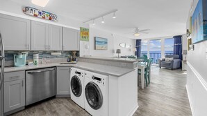 Una cocina moderna con lavavajillas, lavadora y un letrero que dice "PALMS 902".