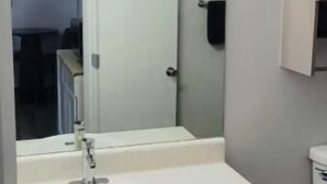 Ein Badezimmer mit Waschbecken, Spiegel und Schrank.