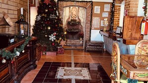 Una sala acogedora con chimenea, un árbol de Navidad y una mesa de centro de madera.