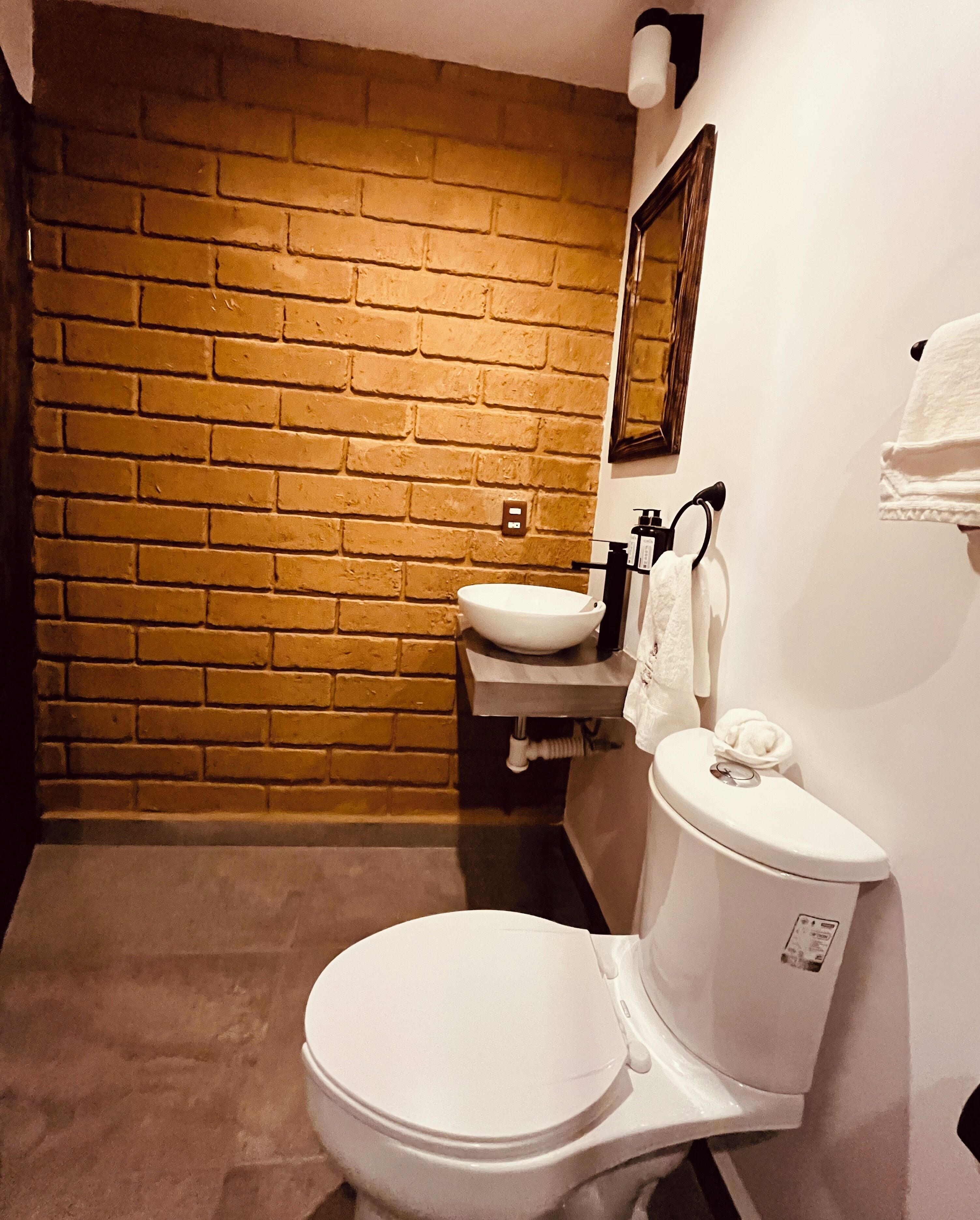 A bathroom with a white toilet, a sink, and a mirror on the wall.