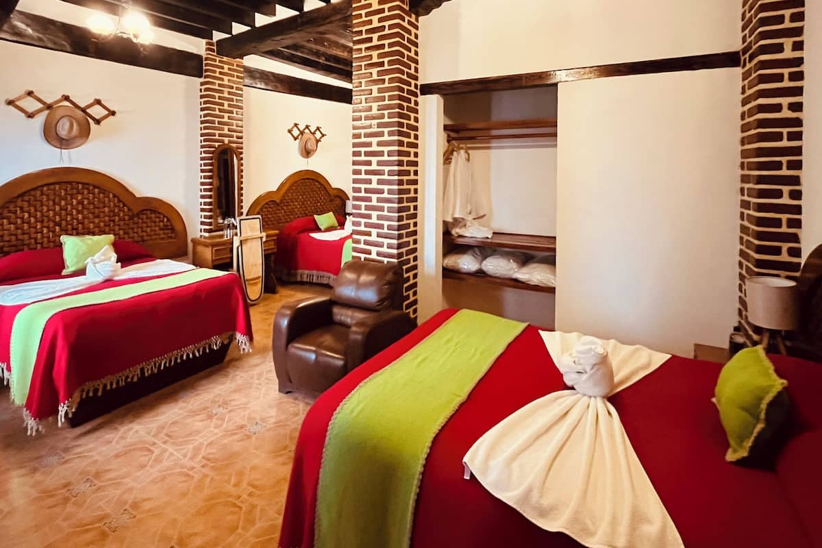 Ein Hotelzimmer mit zwei Betten, einem Massagesessel und einer Backsteinwand.