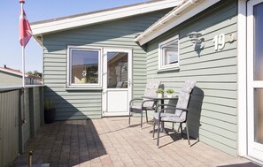 A patio with two chairs and a table, a flag, and a house number 19.