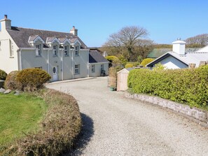 A large, light-colored building with multiple windows and a gravel driveway leading to it. - Maulnagirra (Leap)