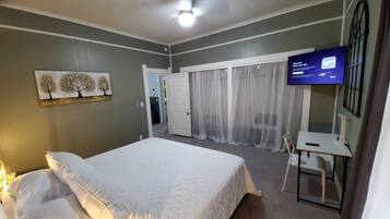 2 habitaciones, escritorio y tabla de planchar con plancha