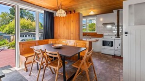 A modern kitchen with wooden cabinetry, a built-in island, and a large window overlooking a garden. - Town Gem with Wi-Fi Taupō, large back yard to run around, short 10 min. stroll to town and lake . (Taupō)