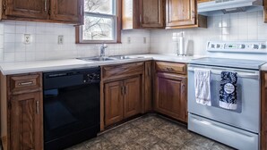 A kitchen with wooden cabinets, a dishwasher, a stove, and a microwave.