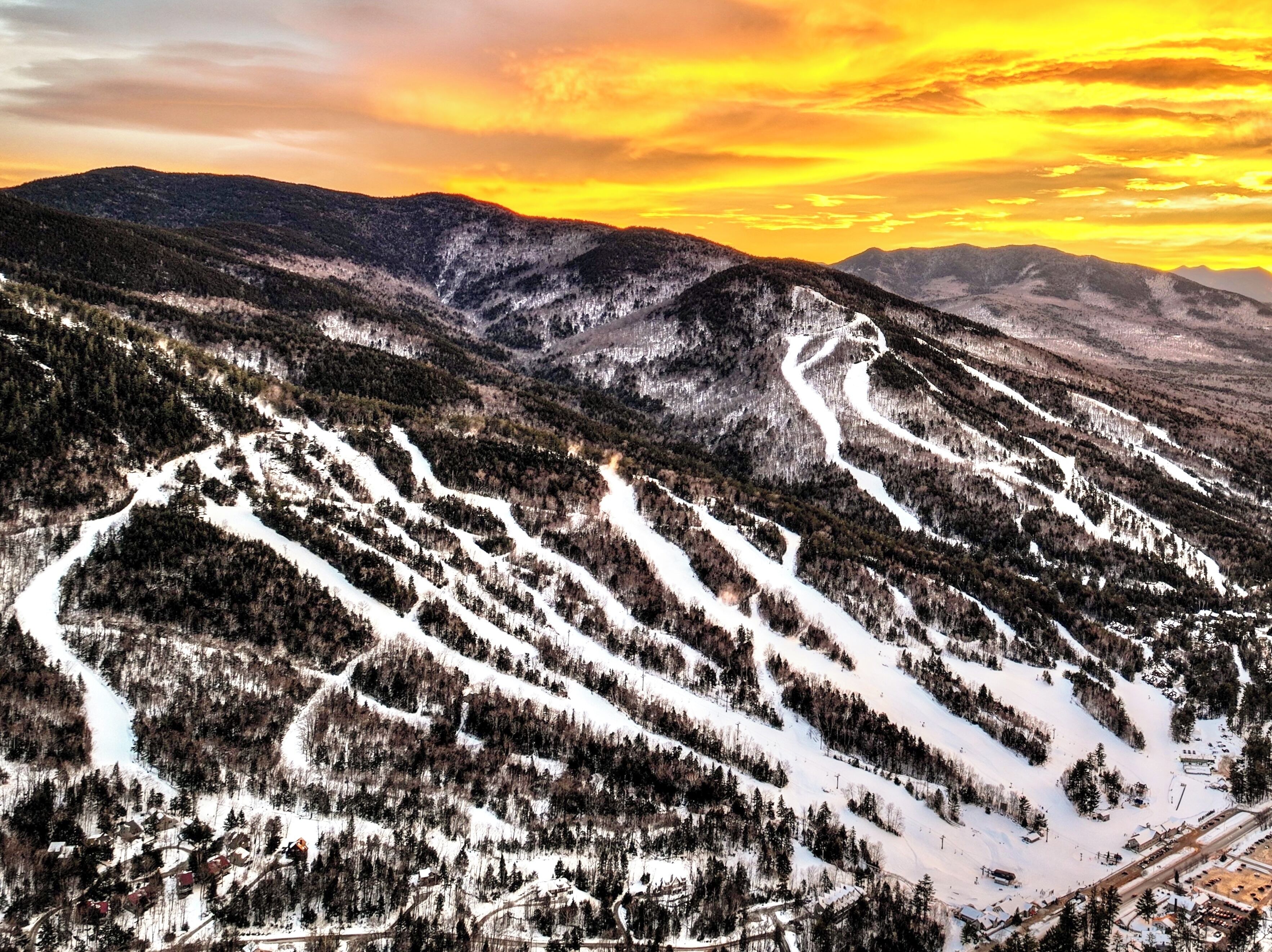 A mountainous landscape with ski trails and a small settlement at the base.