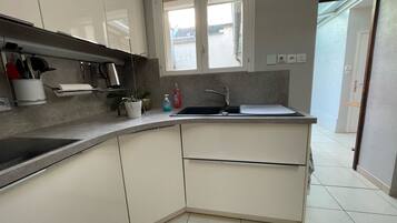 Una cocina moderna con armarios blancos, un lavamanos de acero inoxidable y una ventana sobre la encimera.