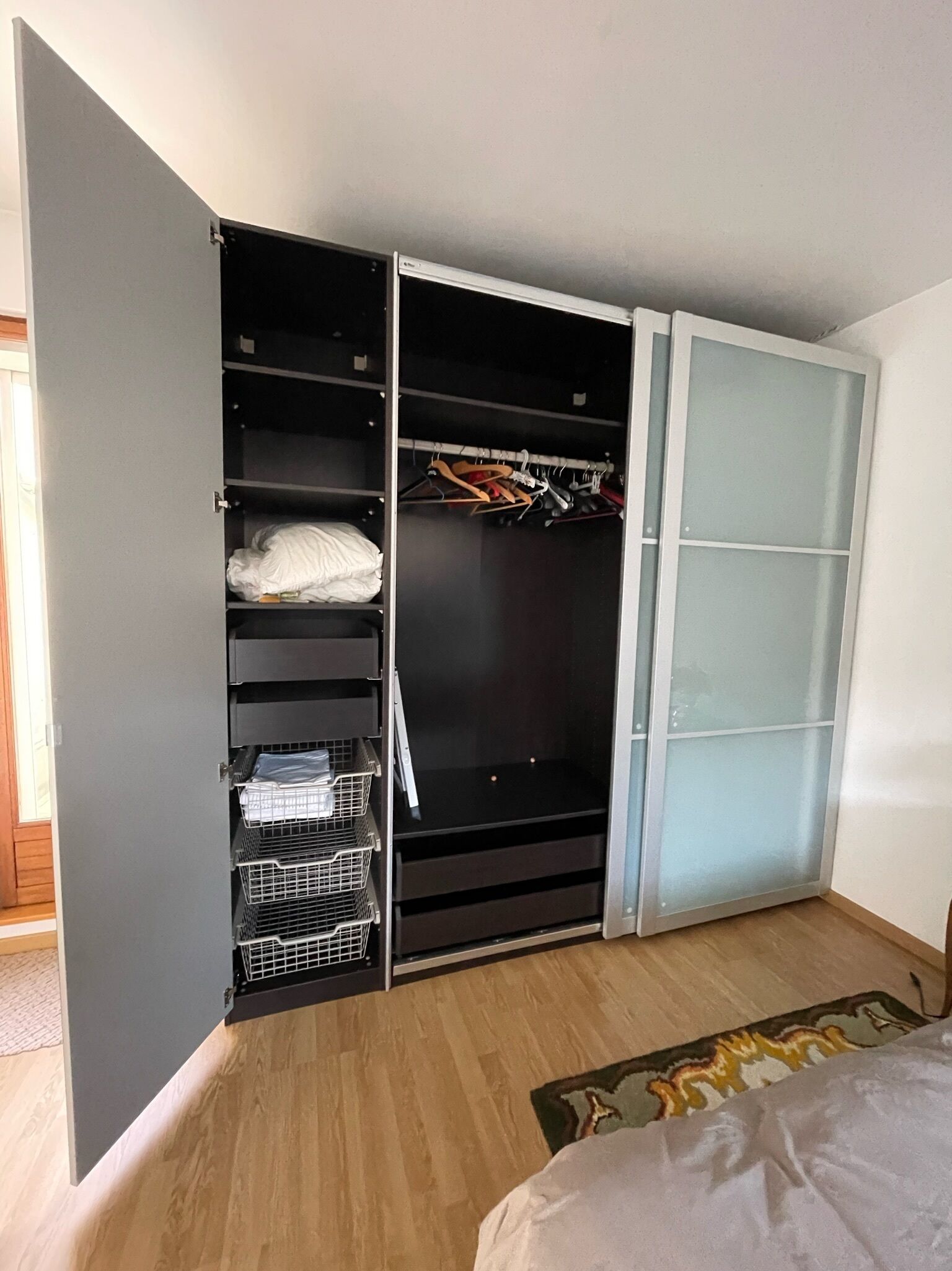 Makuuhuone, jossa on sisäänrakennettu vaatekaappi, sänky ja pieni matto.