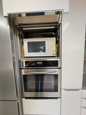 Eine Küche mit integriertem Mikrowellenherd, Backofen und kleinem Kühlschrank.
