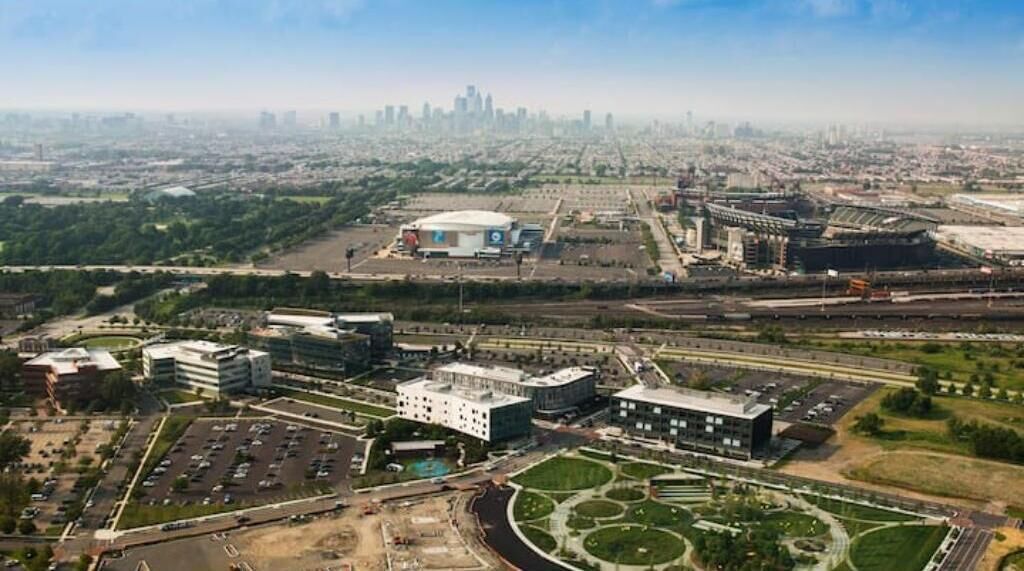 An aerial view of a large complex with multiple buildings, parking areas, and green spaces.