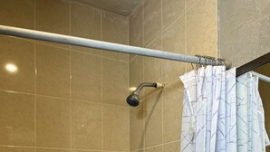 A shower with a glass door, a handheld showerhead, and a towel rack.