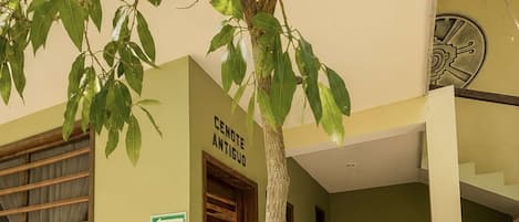 Entrada de un edificio con un letrero que dice 'CENTRO ANTIGO', una puerta de madera y una escalera que da acceso al interior.