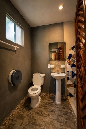 Un baño con inodoro, lavabo y ventana.