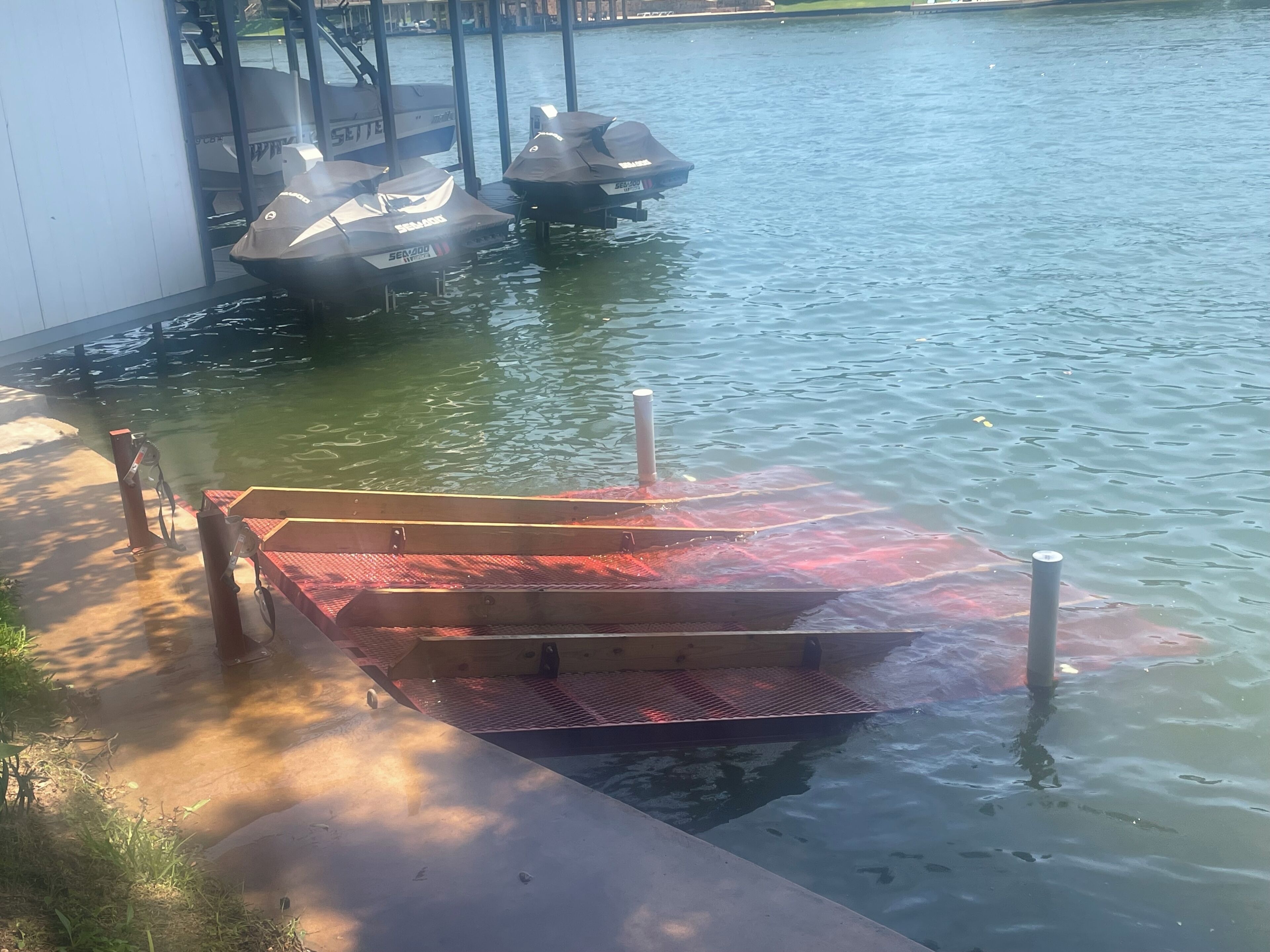 Un molo con una zona salotto coperta e una barca ormeggiata nelle vicinanze.