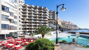 A hotel with a pool, outdoor seating, and a view of the sea. - Home2Book Lighthouse Apt Stunning Sea View Tabaiba (Tabaiba)