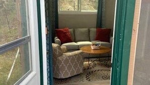Una habitación con sofá, una mesita de centro y un ventilador de techo.