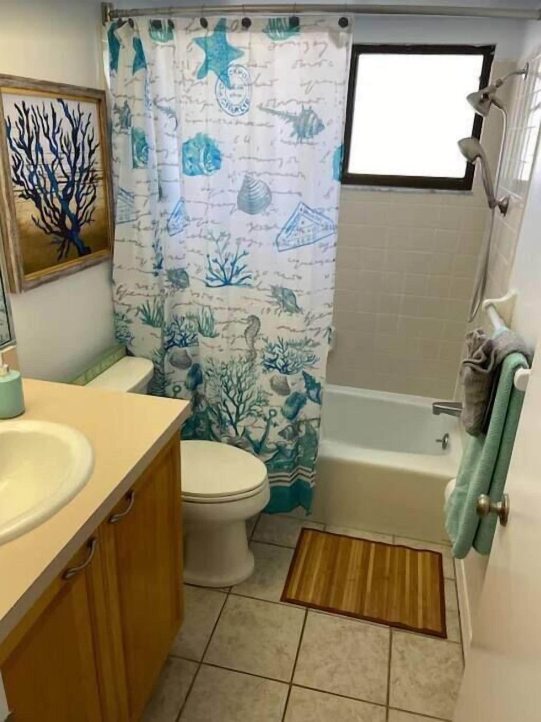 Une salle de bain avec des toilettes, un lavabo et une baignoire.