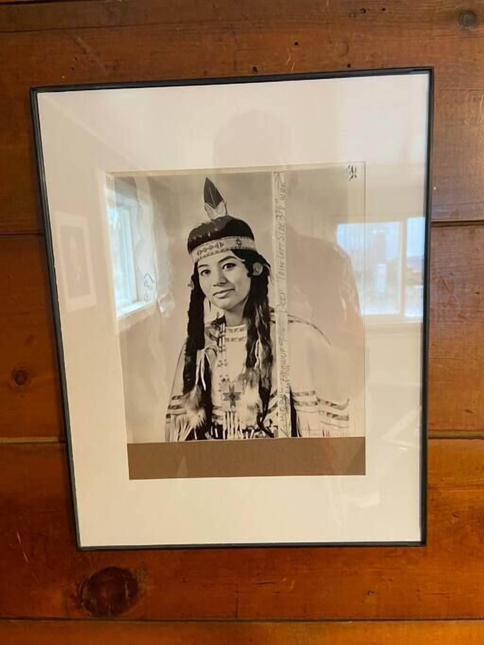A framed black and white photograph of a person in traditional attire.
