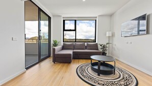 Una sala moderna con un sofá modular, una mesa de centro redonda y una alfombra estampada.