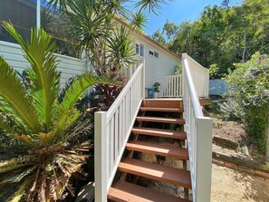 A wooden staircase with white railings leading to a house.