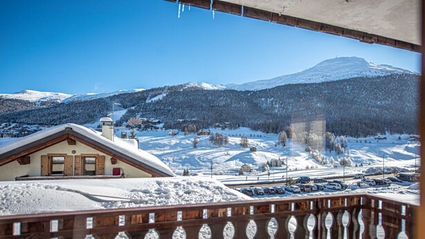 A snow-covered mountain landscape with a chalet-style building in the foreground. - Convenience, comfort and atmosphere at your fingertips. (Livigno)