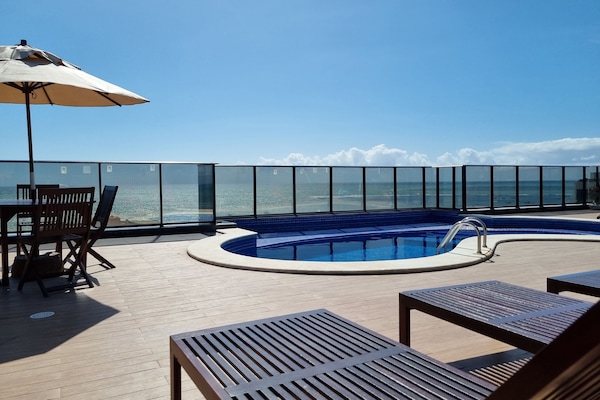 Una piscina al aire libre, sillones reclinables de piscina