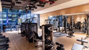 A modern gym with treadmills, weight machines, and a mirror wall. - 532 SEVEN PALM by Design Studio (Dubai)
