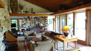 Una sala de estar acogedora con chimenea, una estantería llena de libros y un comedor con mesa y sillas.