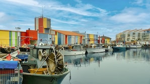 A marina with boats docked, a building with a red roof, and a clear sky. - Appart Abordable avec Terrasse Privée (Le Barcarès)