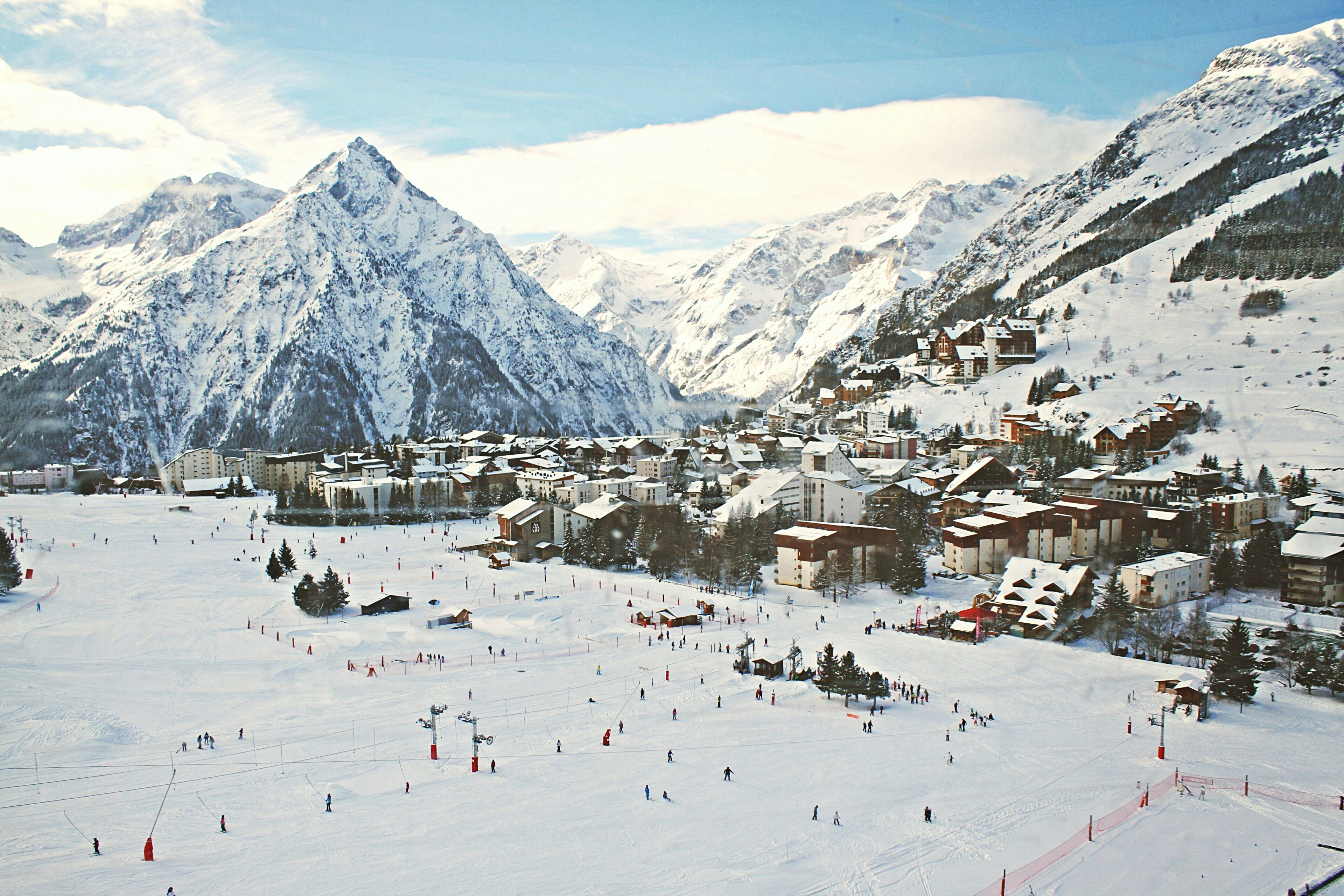 A snow-covered mountain town with ski slopes and buildings.