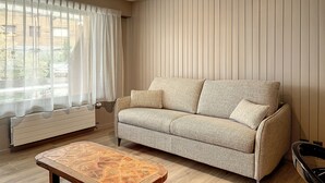 Un salon avec un canapé, une table basse en bois et un radiateur.